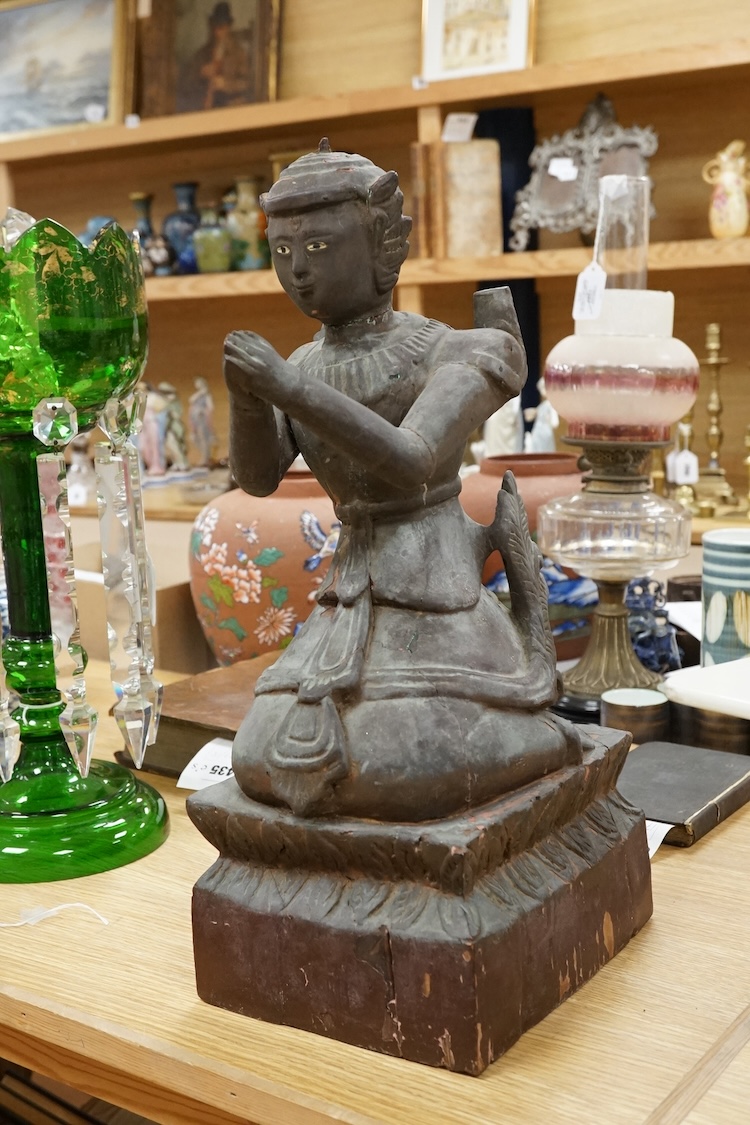 A Thai lacquered wood figure of a kneeling deity, 46cm high.